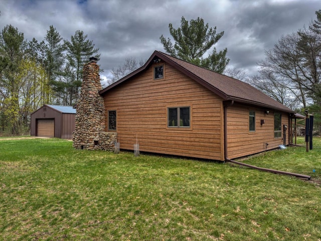 view of home's exterior featuring a lawn, a garage, and an outbuilding