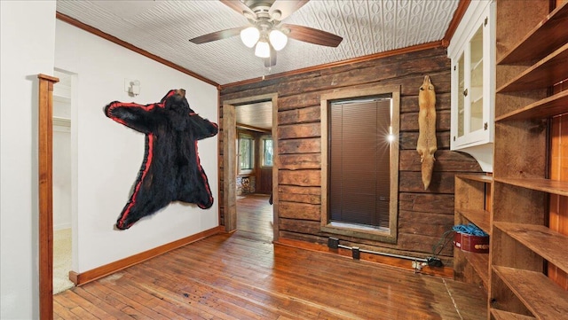 interior space with ceiling fan, wood-type flooring, and ornamental molding