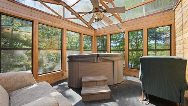 sunroom featuring a healthy amount of sunlight, vaulted ceiling, and a hot tub