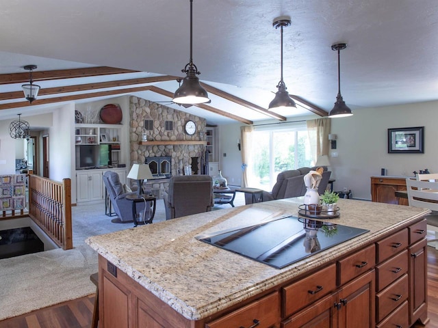 kitchen with black electric stovetop, a center island, decorative light fixtures, and vaulted ceiling with beams