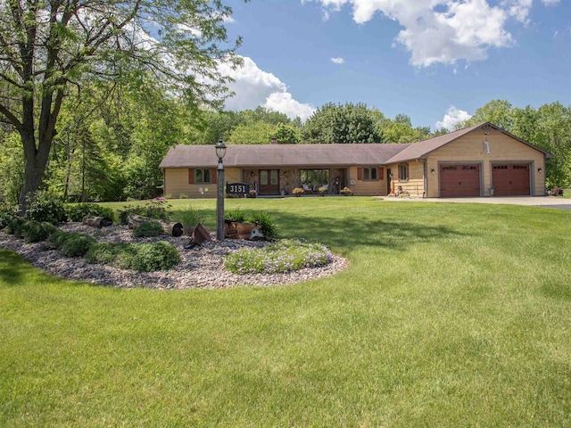 ranch-style house featuring a front yard and a garage