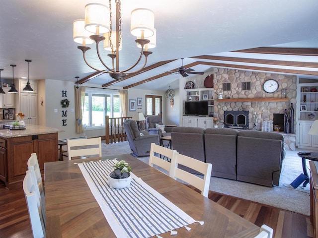 dining space featuring lofted ceiling with beams, ceiling fan with notable chandelier, dark hardwood / wood-style floors, built in shelves, and a fireplace