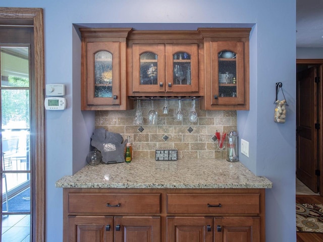 bar with decorative backsplash and light stone countertops