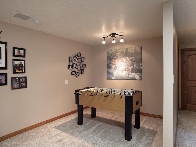 rec room featuring carpet flooring and a textured ceiling