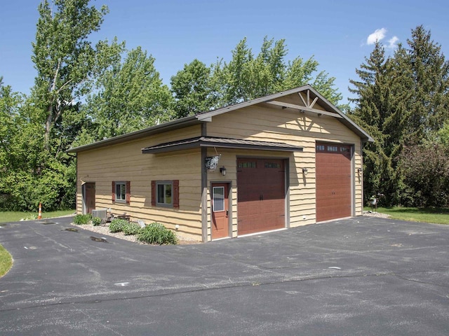 view of front of property featuring a garage and central air condition unit