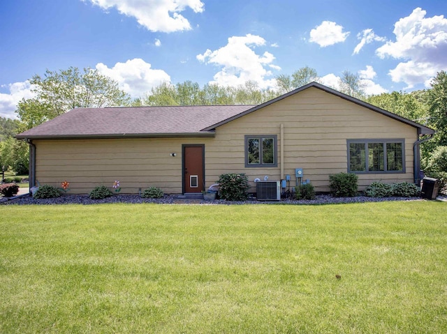 ranch-style home with a front lawn and central AC unit