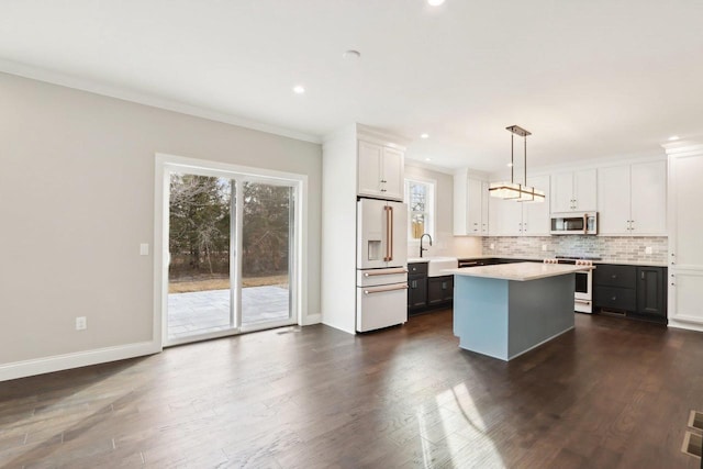 kitchen with crown molding, tasteful backsplash, light countertops, a sink, and high quality appliances