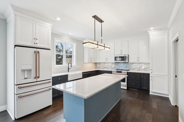 kitchen with high end white fridge, crown molding, stainless steel range oven, white cabinetry, and a sink