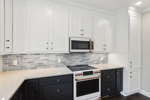 kitchen featuring light stone counters, white appliances, dark wood-style flooring, white cabinets, and decorative backsplash