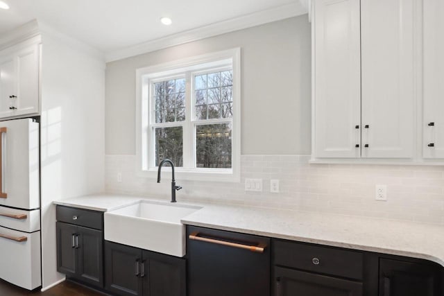 kitchen featuring tasteful backsplash, white cabinetry, a sink, white fridge, and dishwashing machine