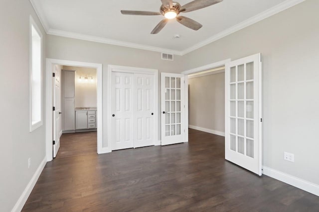 unfurnished bedroom featuring dark wood-style floors, french doors, ornamental molding, and baseboards