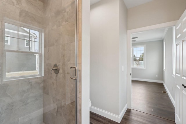 full bathroom with a stall shower, visible vents, baseboards, and wood finished floors