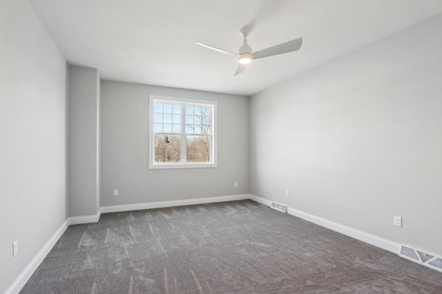 spare room featuring carpet, visible vents, and baseboards