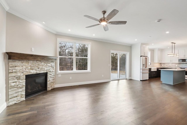 unfurnished living room with ornamental molding, dark wood-type flooring, and baseboards