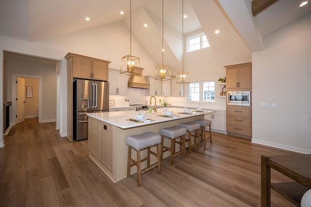 kitchen featuring hardwood / wood-style flooring, a kitchen island with sink, and stainless steel appliances