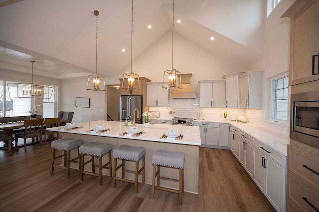 kitchen with a breakfast bar area, a spacious island, dark hardwood / wood-style floors, and appliances with stainless steel finishes