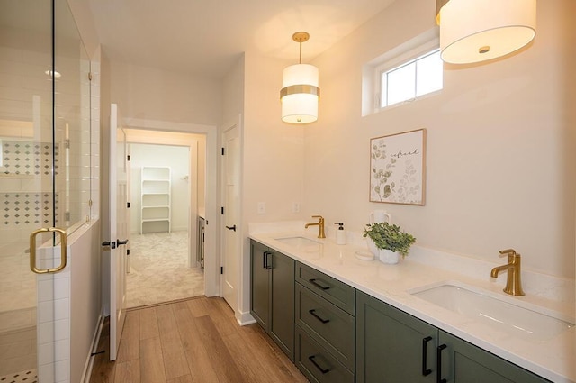 bathroom with vanity, an enclosed shower, and wood-type flooring