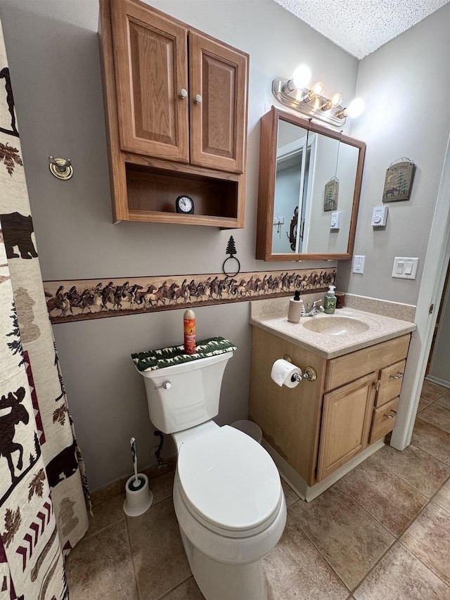 bathroom with vanity, tile patterned floors, a textured ceiling, and toilet