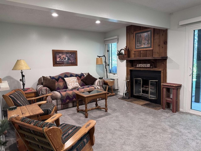 carpeted living room with a textured ceiling and a large fireplace