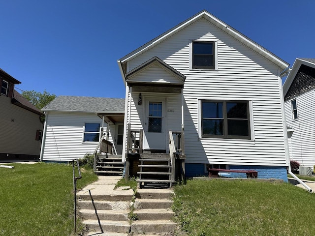 bungalow-style house featuring central AC unit and a front yard