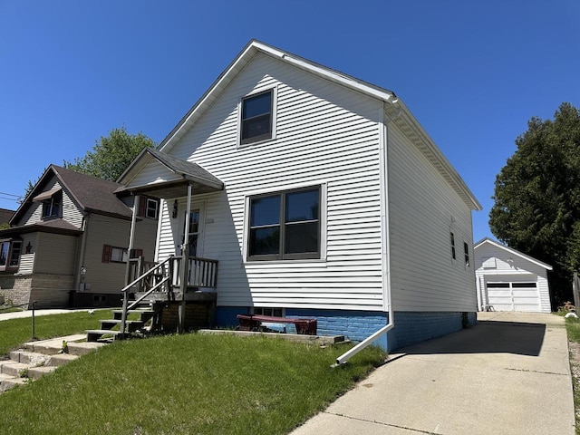 view of front of house featuring an outbuilding, a garage, and a front lawn