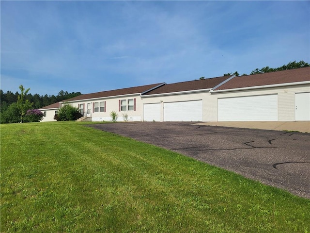 single story home featuring a garage and a front lawn