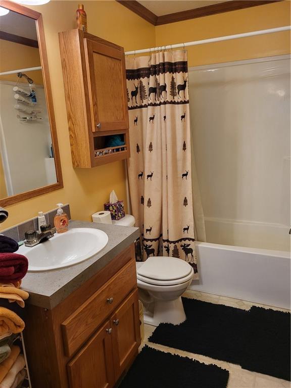 full bathroom with crown molding, vanity, shower / bath combo, and toilet