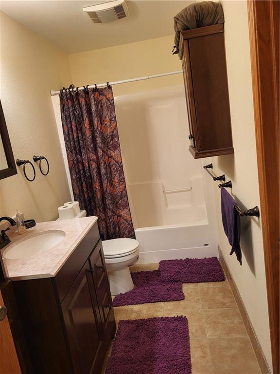 full bathroom with tile patterned floors, vanity, shower / tub combo, and toilet