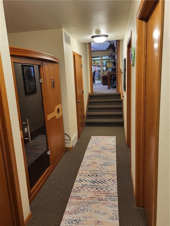 hallway with dark colored carpet