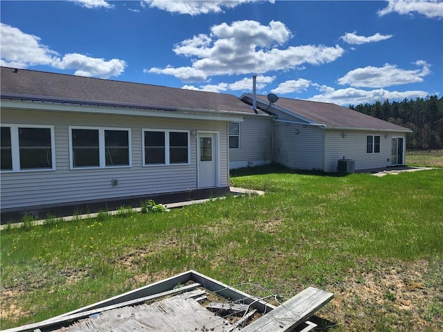 back of property featuring a yard and central AC unit