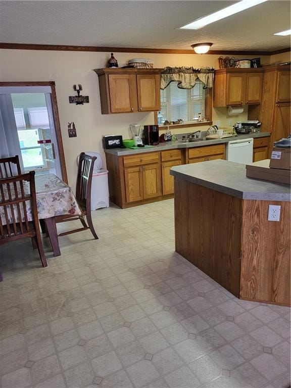 kitchen featuring dishwasher, a textured ceiling, ornamental molding, and sink