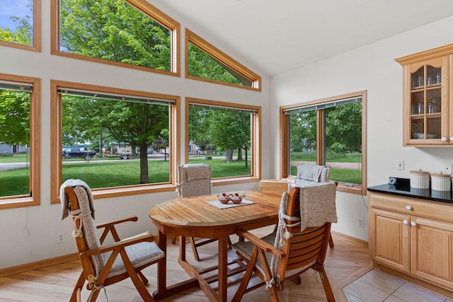 dining room featuring light wood-type flooring and high vaulted ceiling