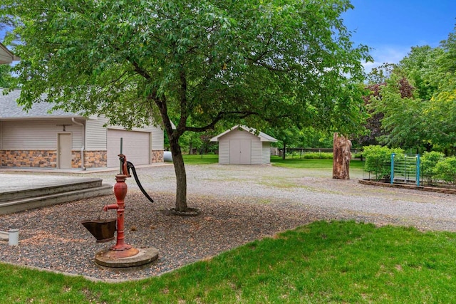 view of yard featuring a garage and a storage shed