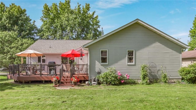 rear view of property with a yard and a wooden deck