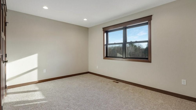 unfurnished room with baseboards, recessed lighting, visible vents, and light colored carpet