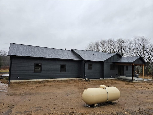 rear view of property with roof with shingles