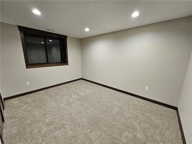 empty room featuring carpet floors, visible vents, baseboards, and recessed lighting