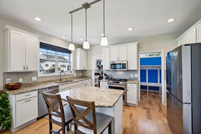 kitchen with white cabinets, light hardwood / wood-style floors, and appliances with stainless steel finishes