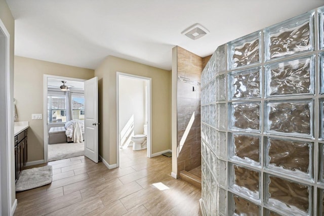 bathroom with vanity, ceiling fan, toilet, walk in shower, and wood-type flooring