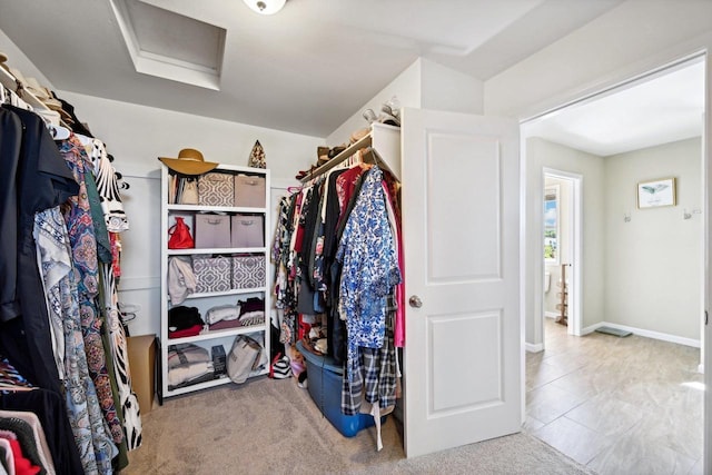 spacious closet with light carpet