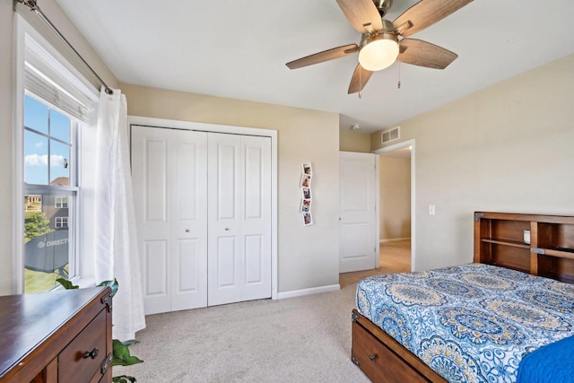 bedroom featuring ceiling fan, light colored carpet, and a closet