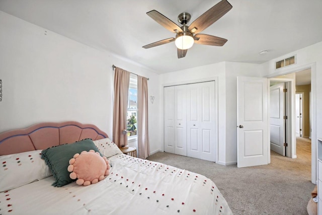 carpeted bedroom with ceiling fan and a closet