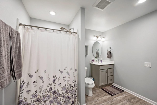 bathroom with hardwood / wood-style flooring, vanity, toilet, and a shower with curtain