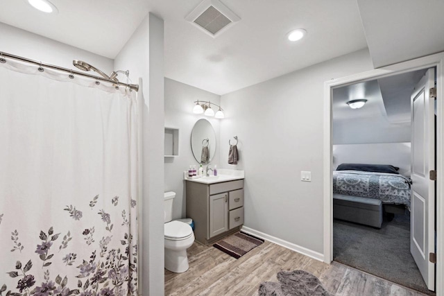 bathroom featuring hardwood / wood-style flooring, vanity, toilet, and a shower with curtain