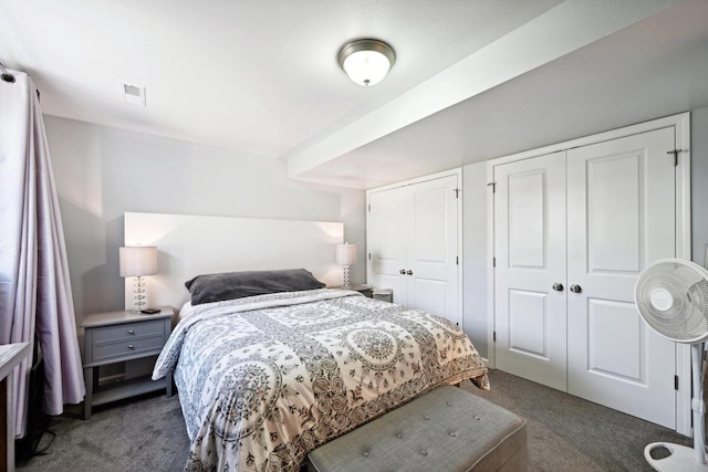 bedroom featuring dark carpet and two closets