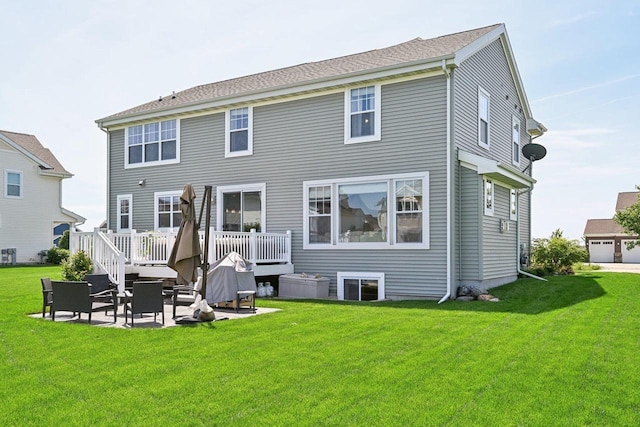 rear view of property featuring a yard, a patio, and a deck