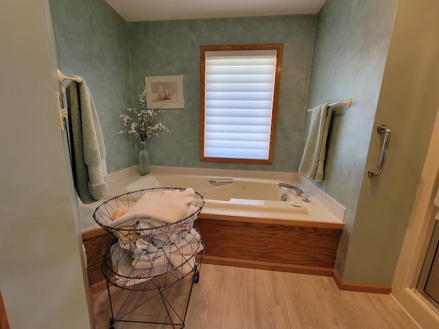 bathroom with a bath and wood-type flooring