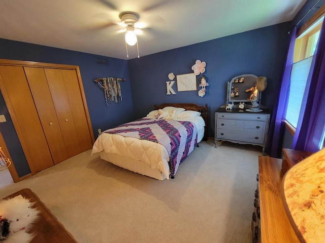 bedroom with carpet, ceiling fan, and a closet