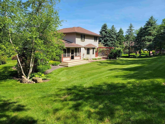 back of house featuring a pergola and a lawn