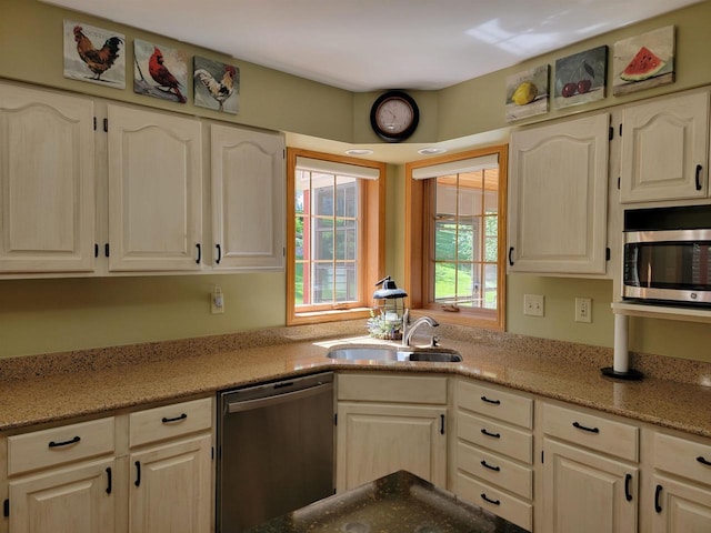 kitchen featuring light stone countertops, sink, and appliances with stainless steel finishes